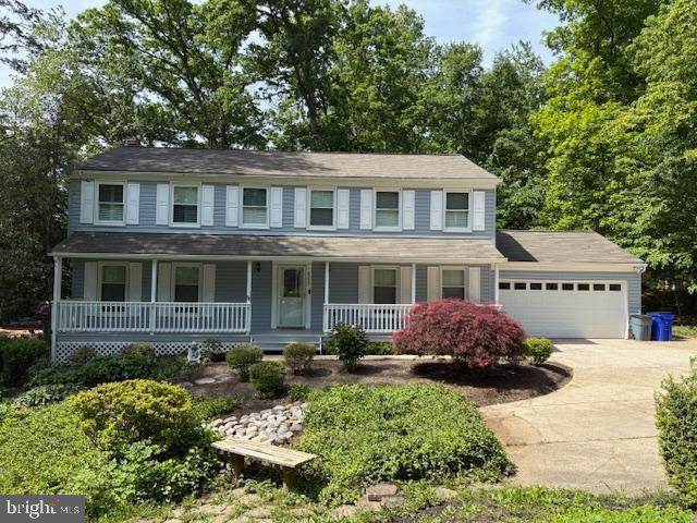 view of front of house with driveway, a garage, and a porch