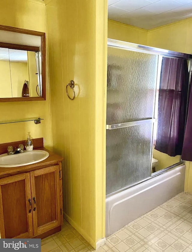 bathroom featuring shower / bath combination with glass door and vanity