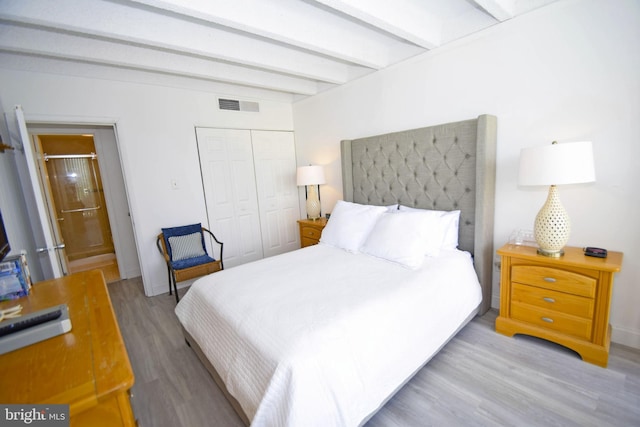 7604 Coastal Hwy Unit 2B, Ocean City, MD 21842 - bedroom with beamed ceiling, wood finished floors, a closet, and ensuite bathroom