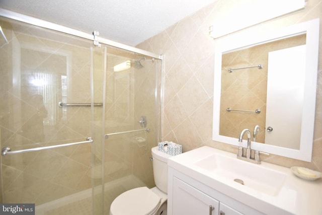 7604 Coastal Hwy Unit 2B, Ocean City, MD 21842 - bathroom featuring vanity, toilet, a stall shower, and tile walls