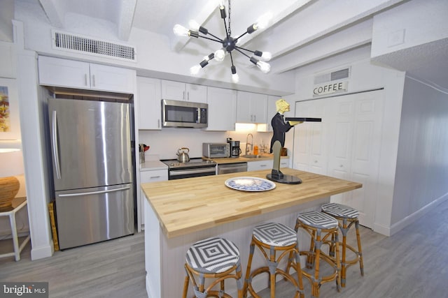 7604 Coastal Hwy Unit 2B, Ocean City, MD 21842 - kitchen with appliances with stainless steel finishes, a chandelier, a sink, light wood-type flooring, and beamed ceiling