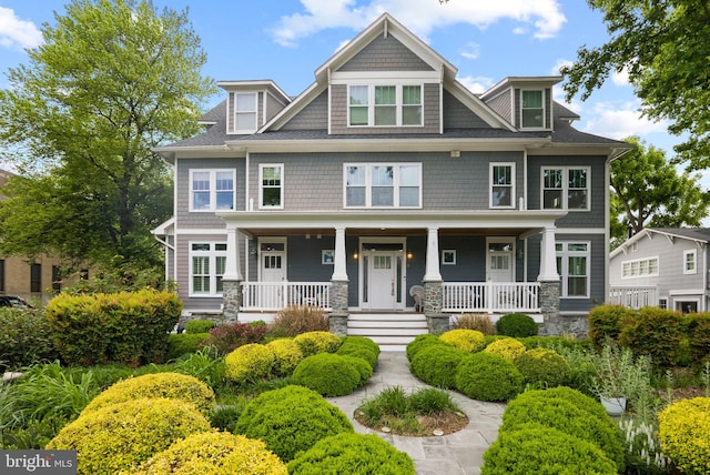 view of front of home with a porch and stone siding