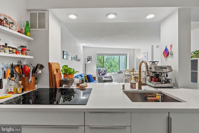2141 Wisconsin Ave NW Unit 103, Washington, DC 20007 - kitchen with black electric cooktop, a sink, light countertops, recessed lighting, and open shelves