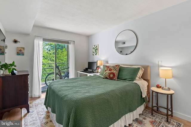 2141 Wisconsin Ave NW Unit 103, Washington, DC 20007 - bedroom with access to exterior, wood finished floors, baseboards, and a textured ceiling