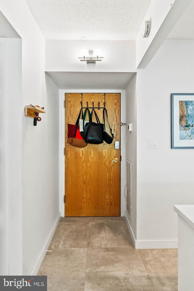 2141 Wisconsin Ave NW Unit 103, Washington, DC 20007 - hallway with baseboards and a textured ceiling