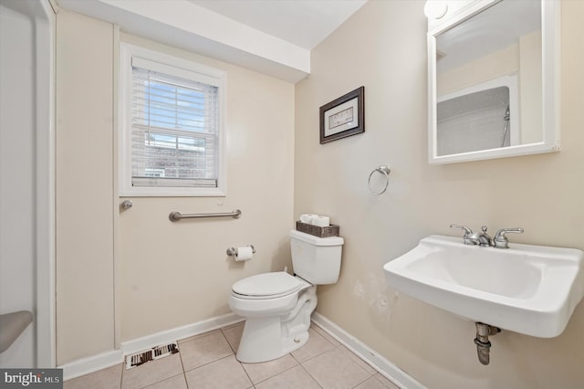 bathroom with baseboards, a sink, toilet, and tile patterned floors