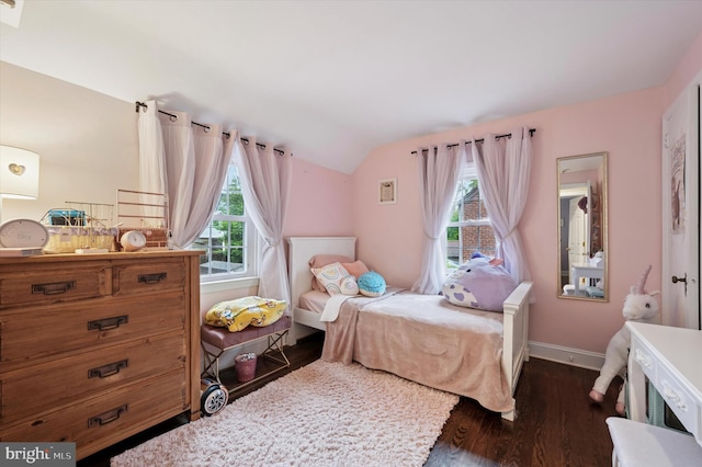 bedroom with lofted ceiling, dark wood finished floors, and baseboards