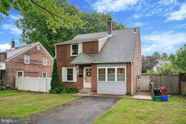 view of front of house with brick siding, a chimney, and entry steps