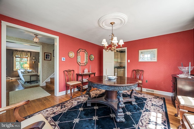 100 Chesney Ln, Erdenheim, PA 19038 - dining room with wood finished floors, a chandelier, wallpapered walls, and stairs