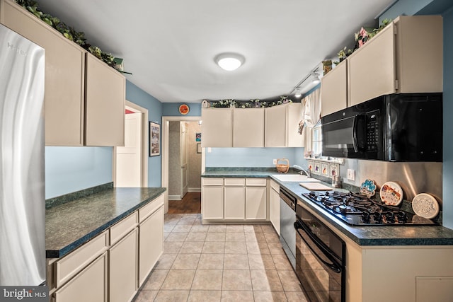 100 Chesney Ln, Erdenheim, PA 19038 - kitchen featuring black appliances, dark countertops, a sink, light tile patterned floors, and cream cabinets