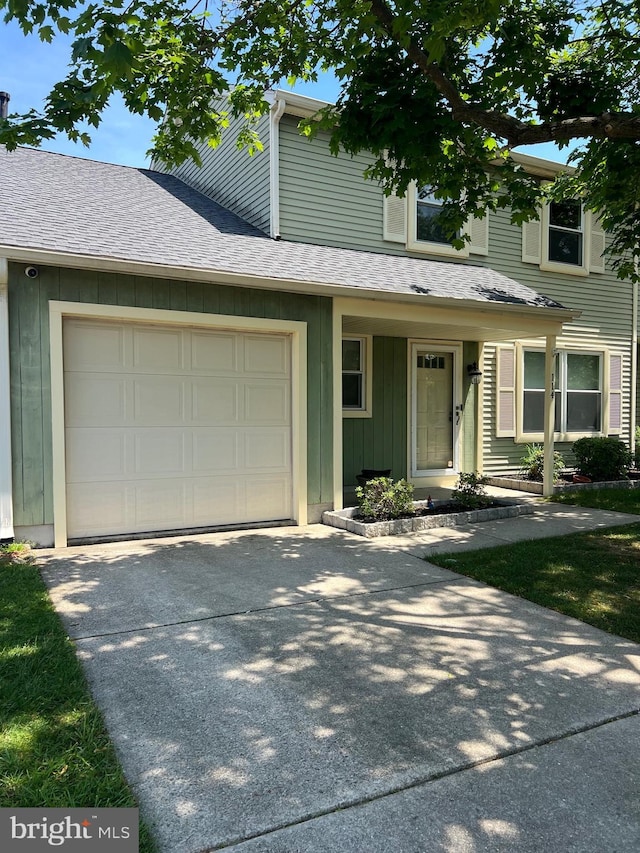 view of front of property with a garage, concrete driveway, board and batten siding, and a shingled roof