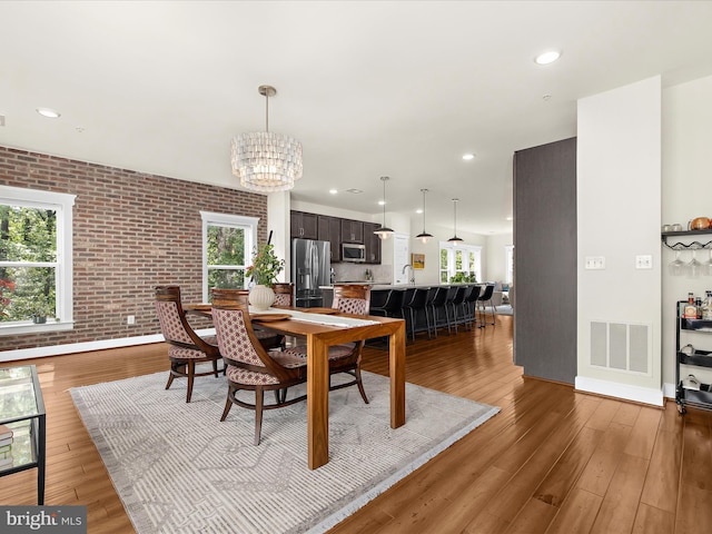 525 Leftwich Ln Unit 78, Annapolis, MD 21401 - dining room with a chandelier, light wood finished floors, brick wall, baseboards, and recessed lighting