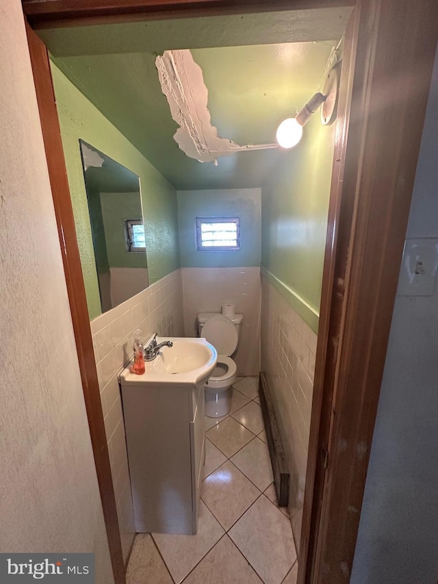 1139 Snyder Ave, Philadelphia, PA 19148 - half bathroom featuring toilet, tile walls, tile patterned floors, vanity, and a wainscoted wall