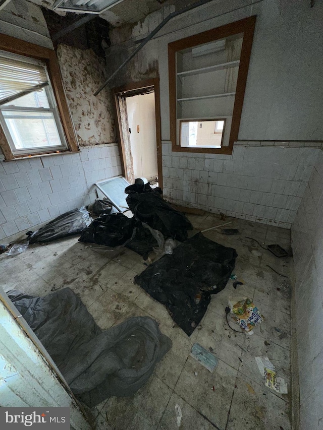 empty room featuring healthy amount of natural light and concrete block wall