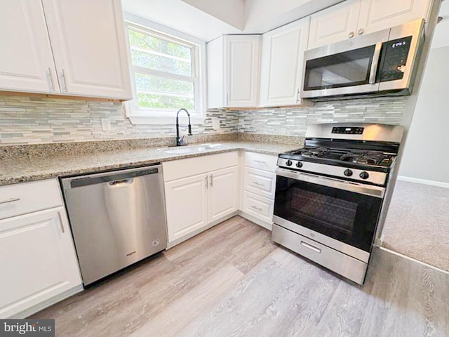 112 Hemlock Dr, Williamstown, NJ 08094 - kitchen featuring appliances with stainless steel finishes, a sink, light wood-style flooring, and white cabinetry