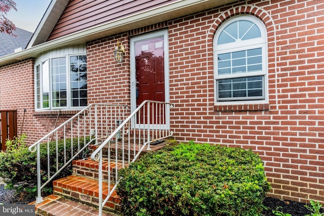 entrance to property featuring brick siding