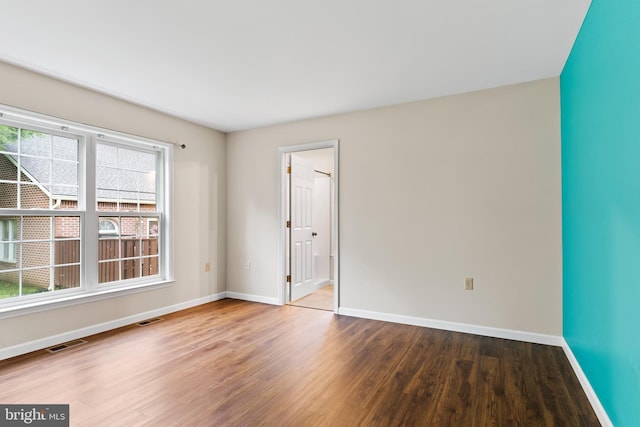 spare room with wood finished floors and baseboards