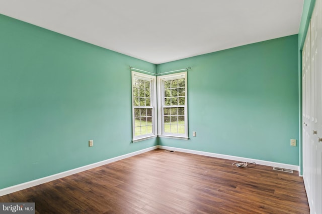 empty room with wood finished floors and baseboards