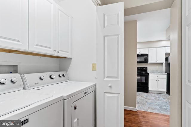 washroom featuring cabinet space, separate washer and dryer, wood finished floors, and baseboards