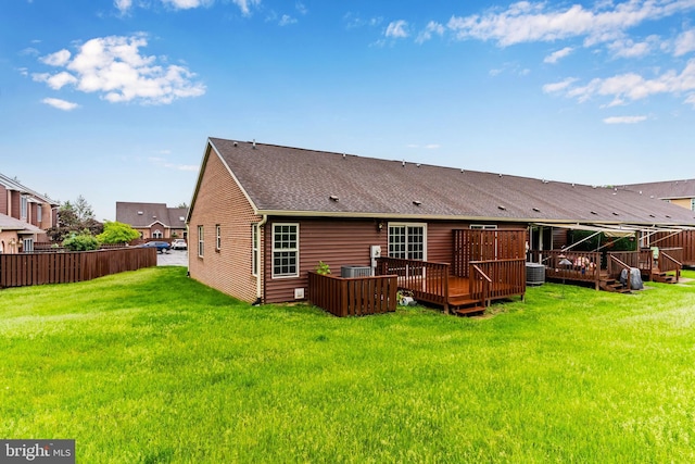 rear view of house with central AC, a deck, and a shingled roof