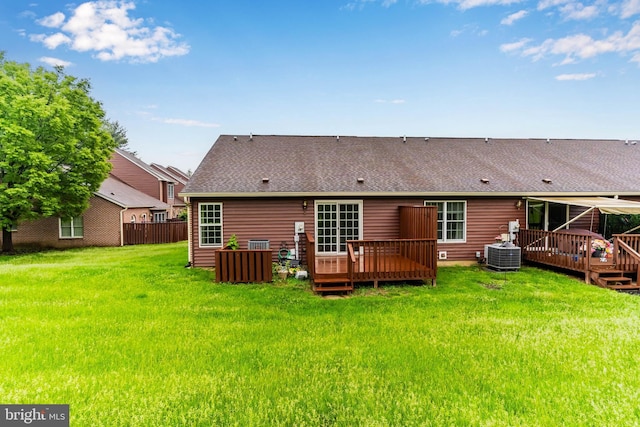 back of property featuring a deck, central AC, a shingled roof, and a yard