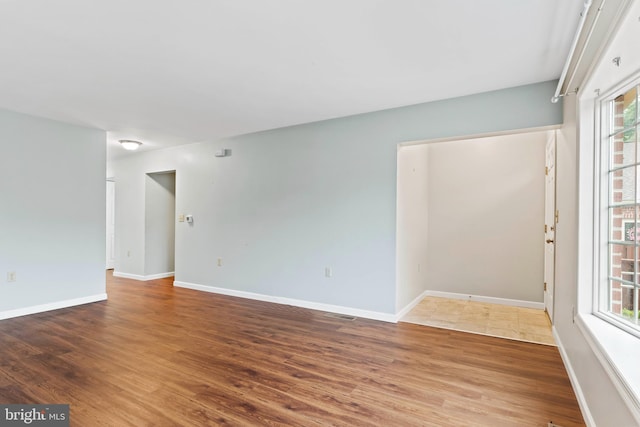 empty room featuring wood finished floors and baseboards