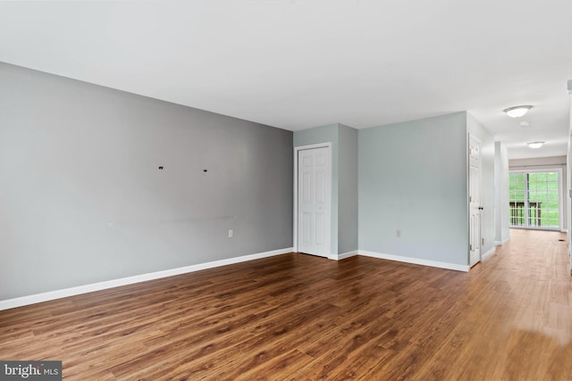 empty room featuring wood finished floors and baseboards