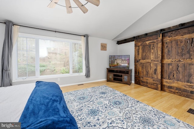 bedroom with lofted ceiling, wood finished floors, baseboards, and ceiling fan