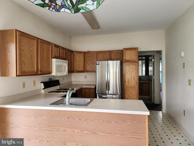 16 Lantern Ln, Columbus, NJ 08022 - kitchen featuring white appliances, a peninsula, a sink, light flooring, and light countertops