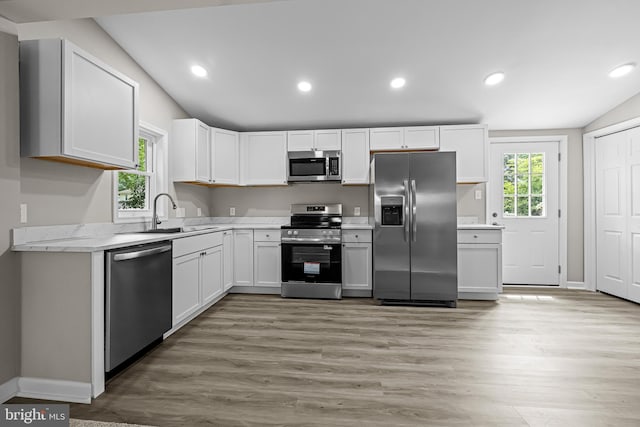 10 E Chestnut St, Delmar, MD 21875 - kitchen featuring stainless steel appliances, a sink, lofted ceiling, light wood-style flooring, and white cabinetry