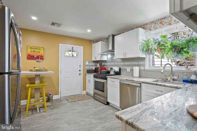 449 7th Ave, Lindenwold, NJ 08021 - kitchen featuring appliances with stainless steel finishes, wall chimney exhaust hood, a sink, tasteful backsplash, and white cabinets