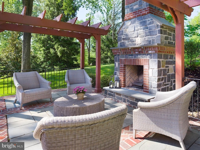 view of patio featuring an outdoor stone fireplace and fence