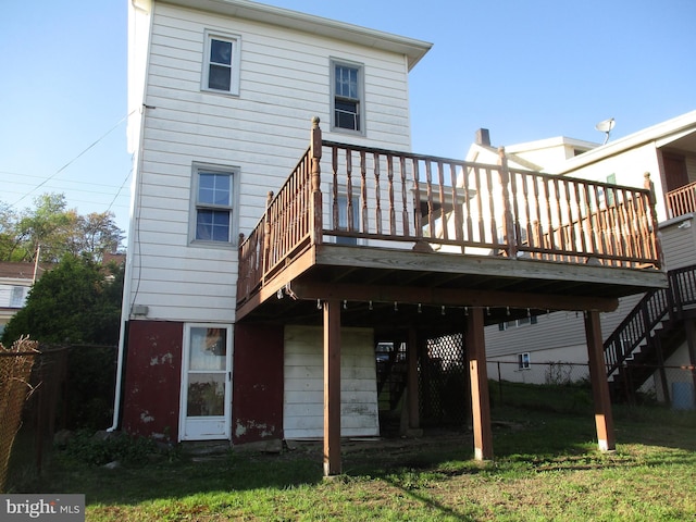 back of property with a deck and stairs