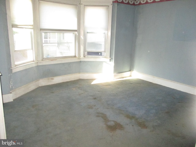 unfurnished room with baseboards