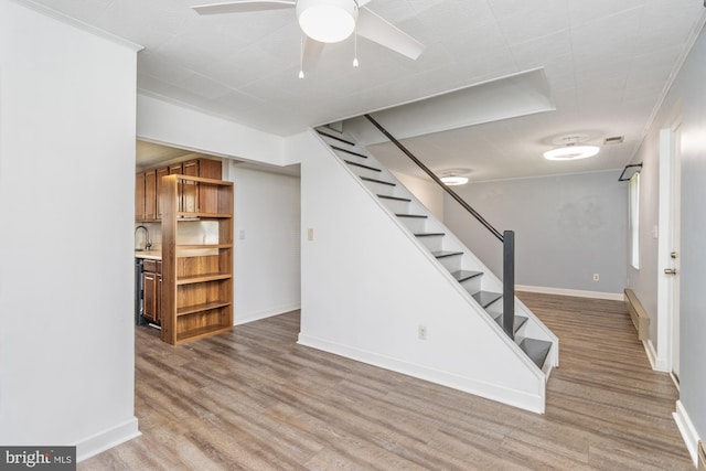 3135 Sollers Point Rd, Baltimore, MD 21222 - finished basement with wood finished floors, stairway, baseboards, ceiling fan, and crown molding