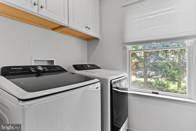 clothes washing area with cabinet space and independent washer and dryer