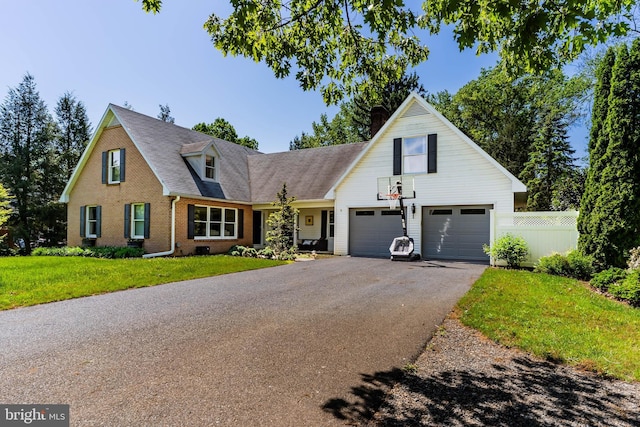 view of front facade featuring asphalt driveway, brick siding, a garage, a chimney, and a shingled roof