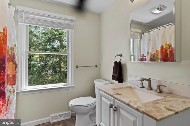 bathroom featuring toilet, wood finished floors, vanity, and baseboards
