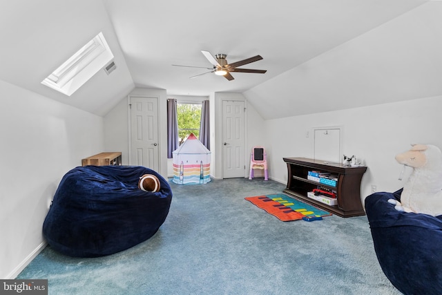 recreation room featuring lofted ceiling, a ceiling fan, a skylight, carpet, and baseboards