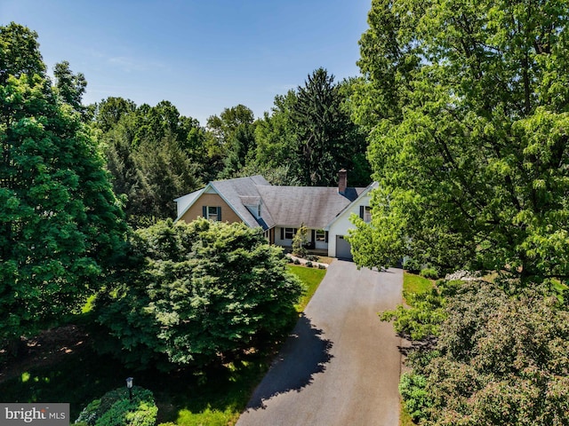 aerial view of property and surrounding area with a heavily wooded area