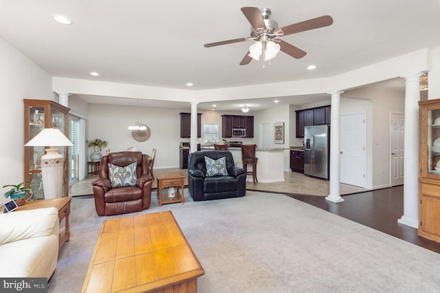 living area featuring ornate columns, recessed lighting, ceiling fan, and wood finished floors