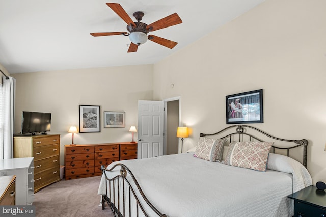 bedroom with light carpet, vaulted ceiling, and a ceiling fan