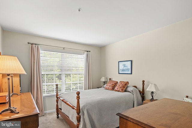 bedroom featuring light colored carpet and baseboards