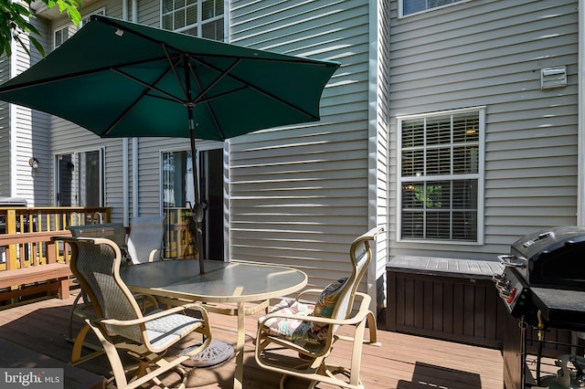 wooden deck with outdoor dining area and area for grilling