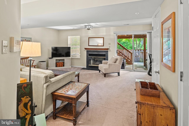 living room featuring carpet, healthy amount of natural light, a fireplace with flush hearth, and baseboards