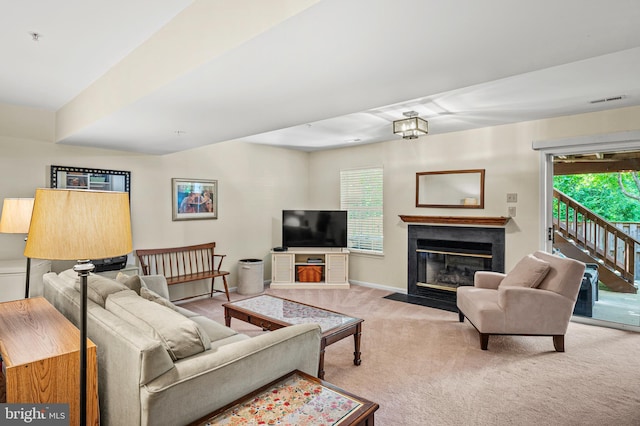 carpeted living area with a fireplace with flush hearth, healthy amount of natural light, and baseboards