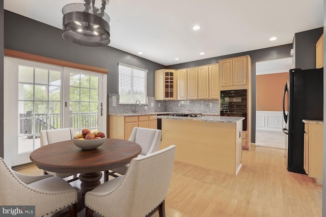 43413 Countrywalk Ct, Ashburn, VA 20147 - kitchen featuring black appliances, a center island, a sink, light brown cabinets, and light wood-type flooring