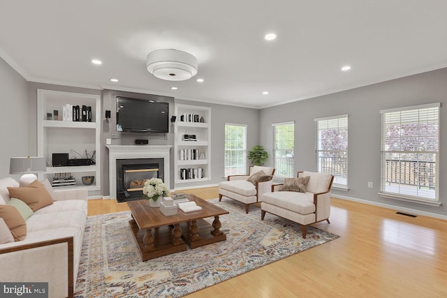 43413 Countrywalk Ct, Ashburn, VA 20147 - living room featuring ornamental molding, wood finished floors, a fireplace with flush hearth, recessed lighting, and built in shelves