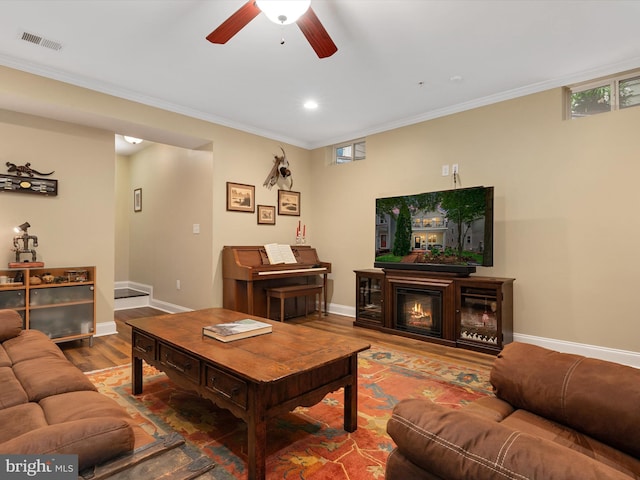816 Bay Ridge Ave, Annapolis, MD 21403 - living area with wood finished floors, a ceiling fan, baseboards, ornamental molding, and a glass covered fireplace