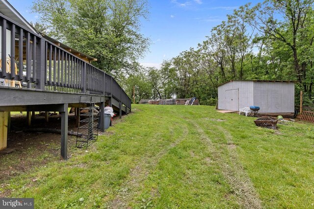 1604 Old New Windsor Rd, New Windsor, MD 21776 - view of grassy yard with an outdoor fire pit, a storage unit, a wooden deck, and an outdoor structure